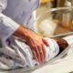 Obstetrician comforting baby in cradle