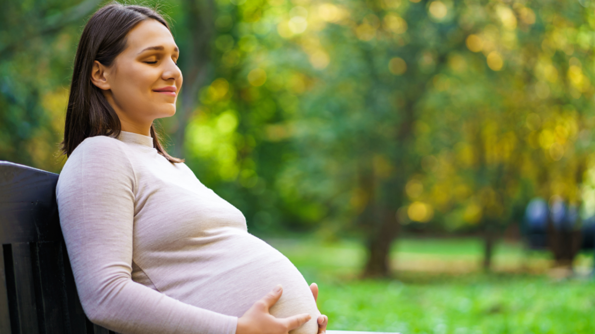 Pregnant woman sitting on park bench