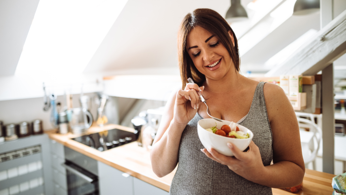 Woman managing pregnancy cravings by eating fruit