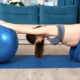 Pregnant woman with sciatica stretching using an exercise ball