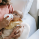 Mother feeding baby thawed breast milk