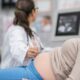a pregnant woman getting an ultrasound from her obgyn